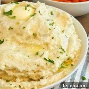 bowl of cream cheese mashed potatoes with butter and parsley.