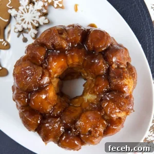 A ring of monkey bread is placed on a white platter next to gingerbread cookies.
