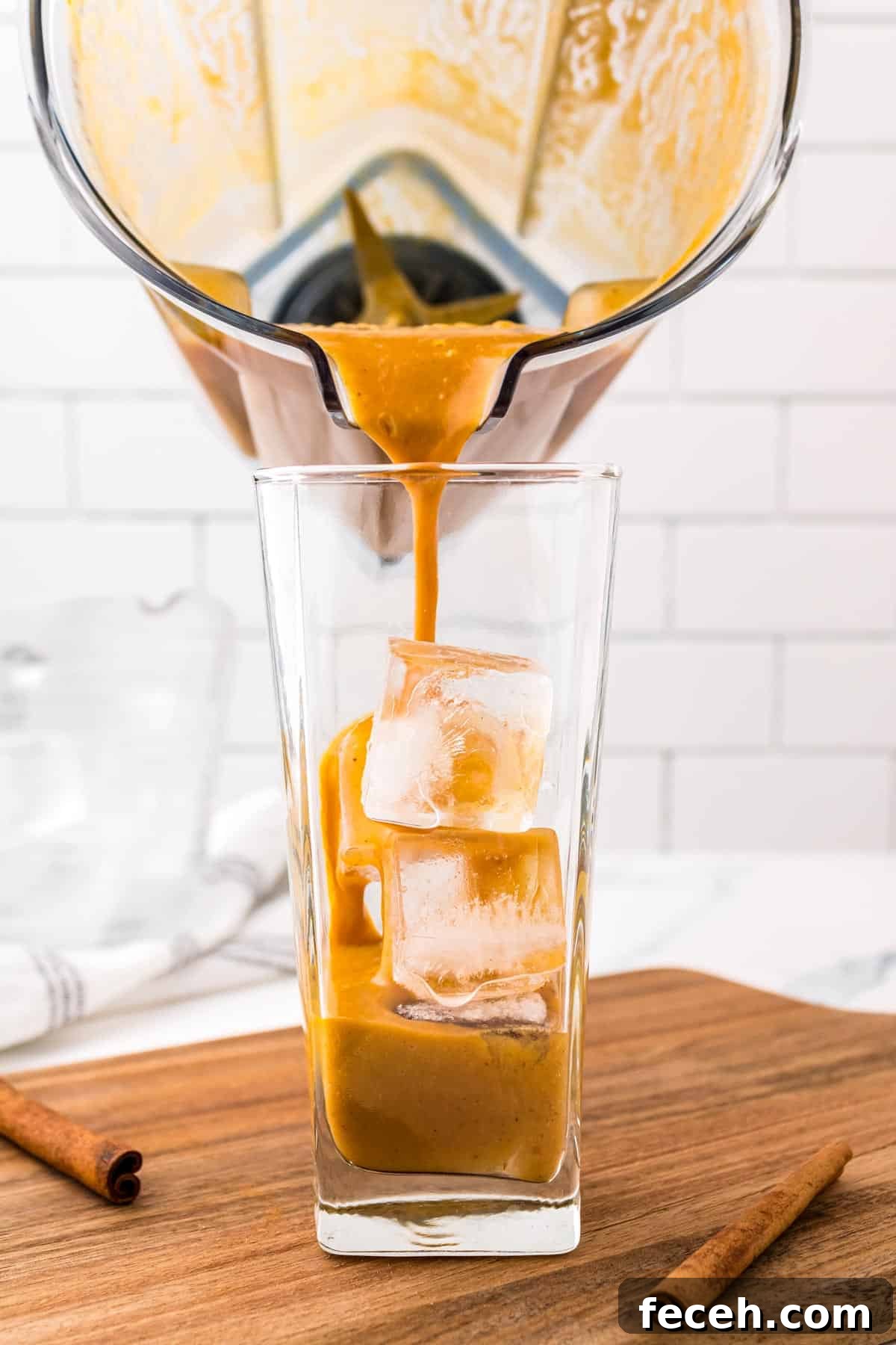 Fall coffee drink being poured over ice in a glass.