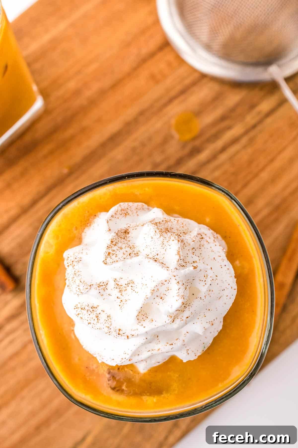 Overhead view of a pumpkin spice coffee topped with a dollop of whipped cream.