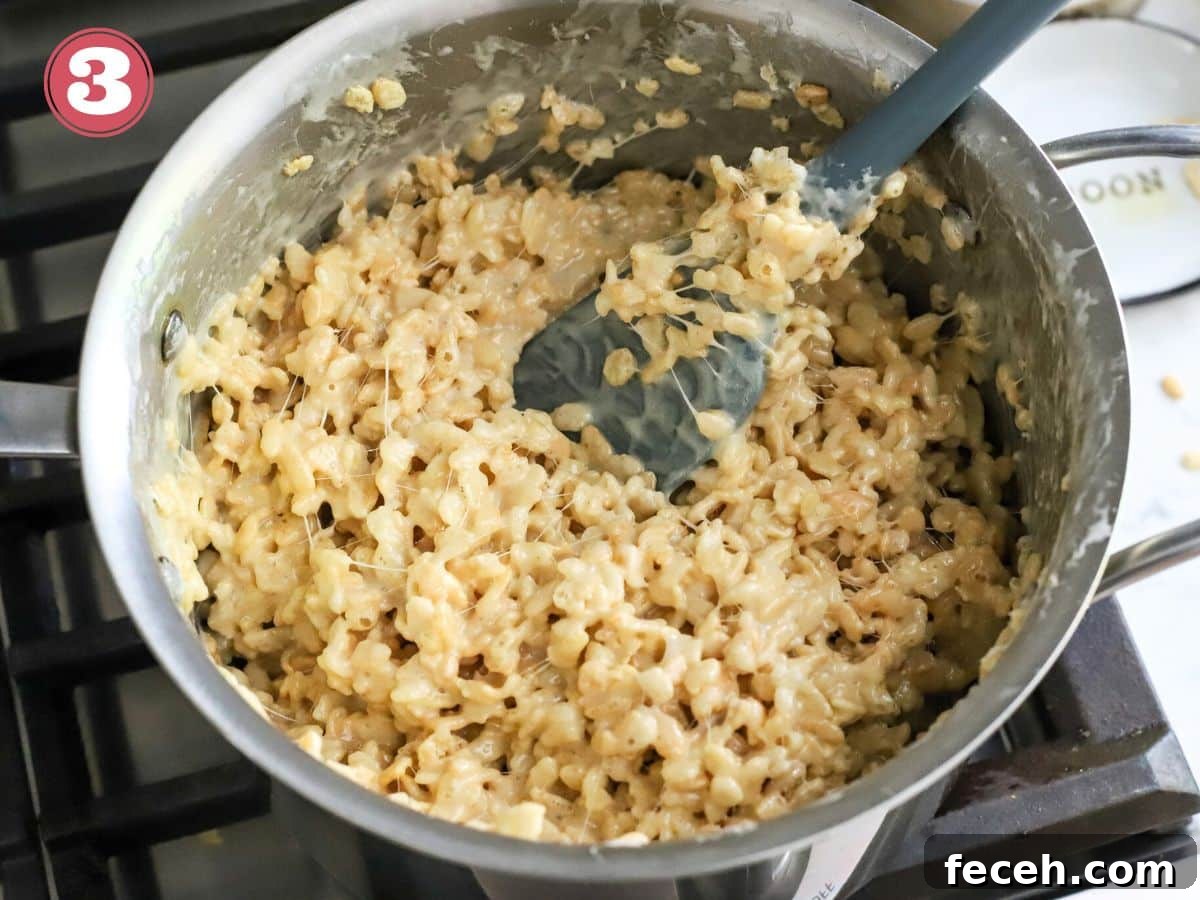 Fourth of July Rice Krispie Treats: Patriotic Red, White & Blue Recipe 4 Rice krispies cereal being added to marshmallows on the stove.