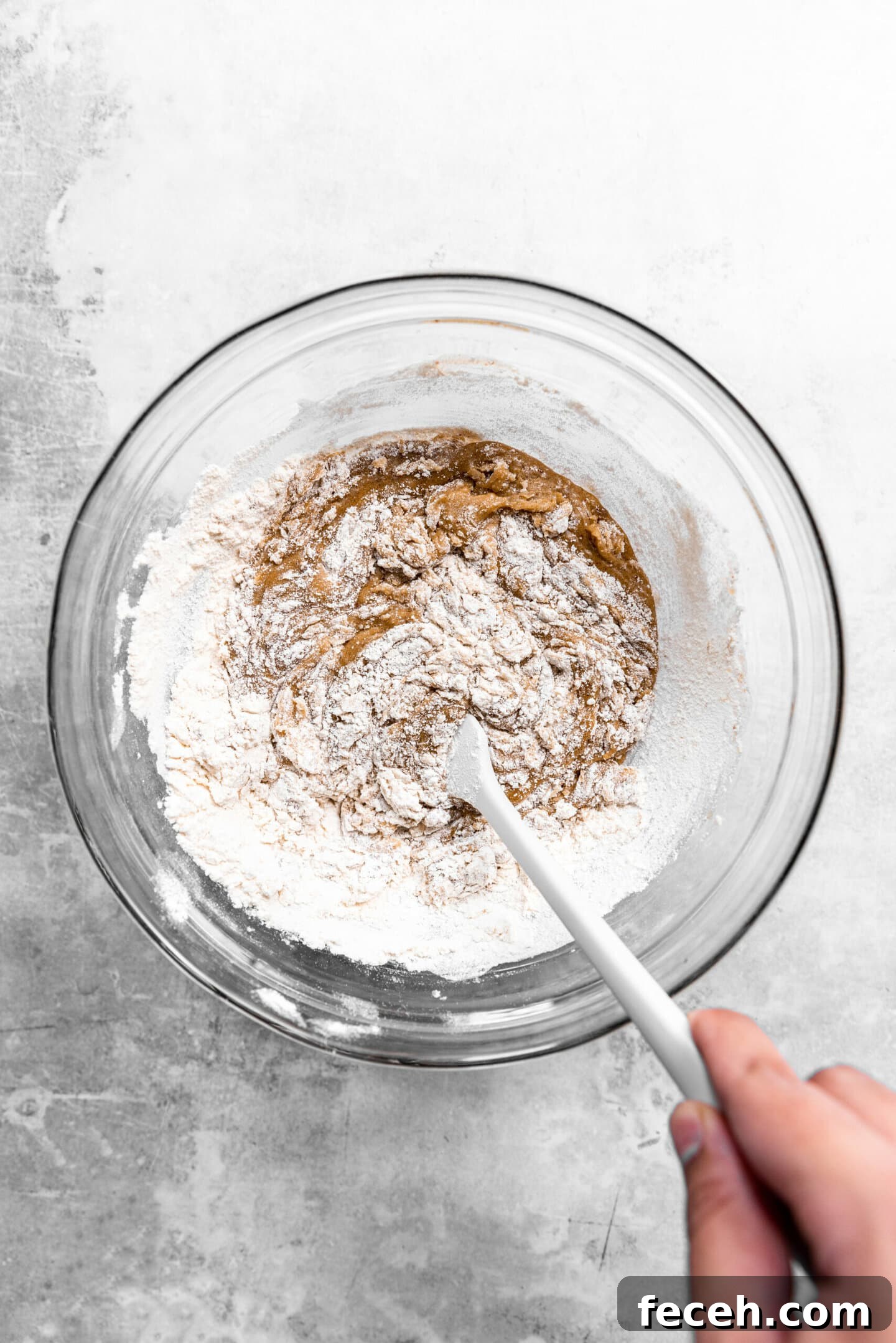 Dry ingredients being folded into wet ingredients.