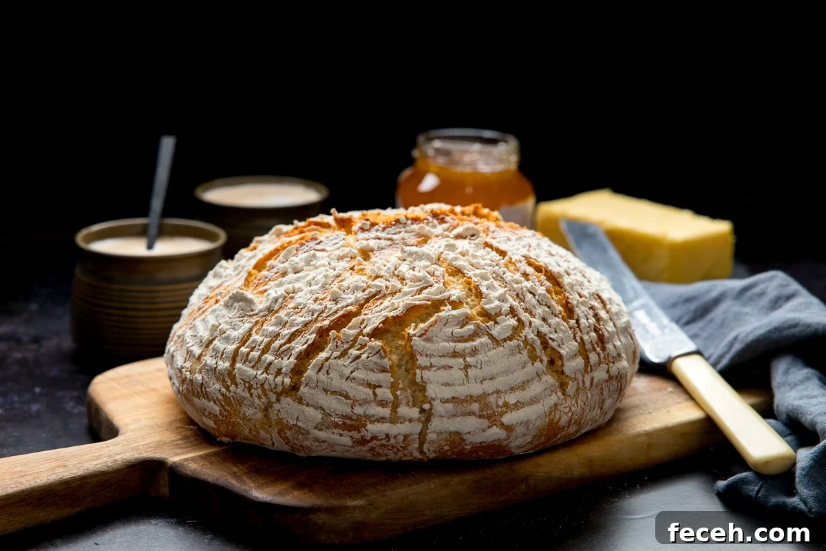 Wide image of a loaf of artisan bread on a wooden chopping board
