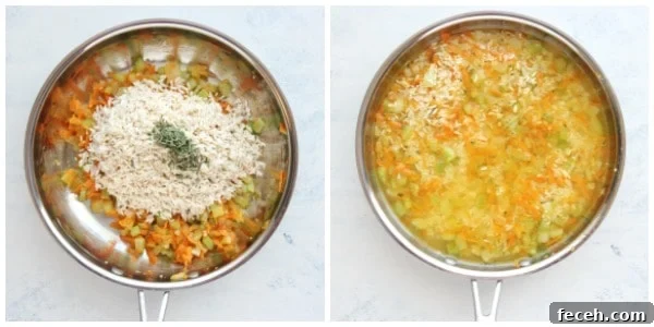 Veggies and rice with stock in a skillet.