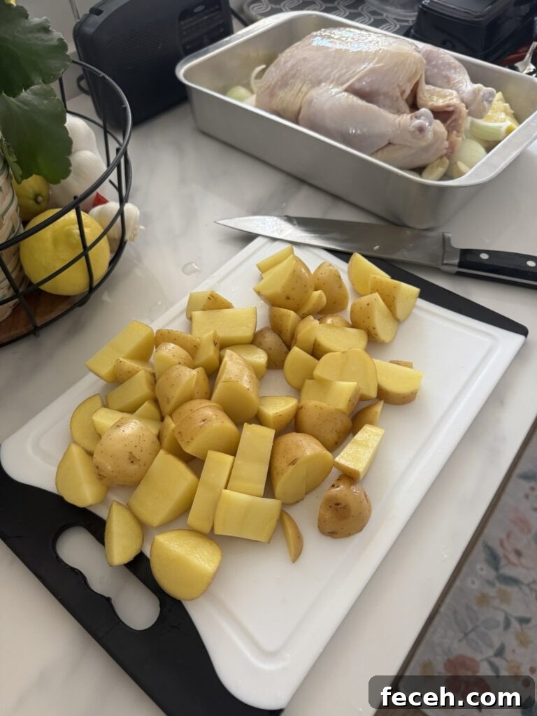 Citrus Herb Roast Chicken for Summer Gatherings 4 Chopped potatoes on a cutting board in front of raw chicken in a baking dish