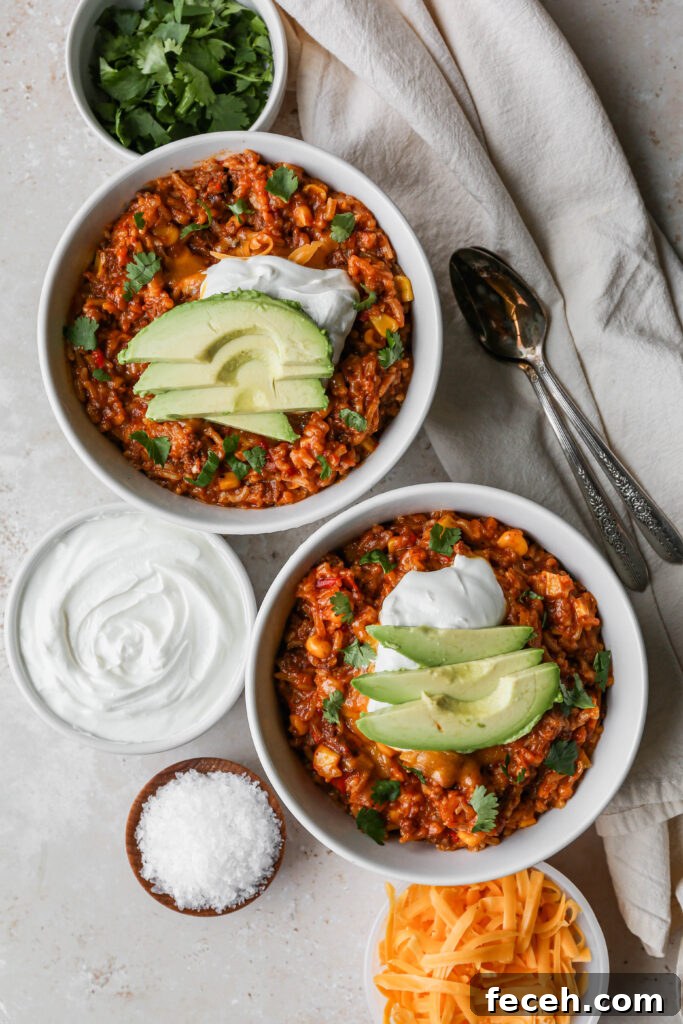 Instant Pot Mexican Beef and Rice Recipe for Flavorful Weeknight Meals 2 two white bowls of instant pot mexican style beef and rice next to a small white bowl of chopped cilantro and a small white bowl of shredded cheddar cheese.