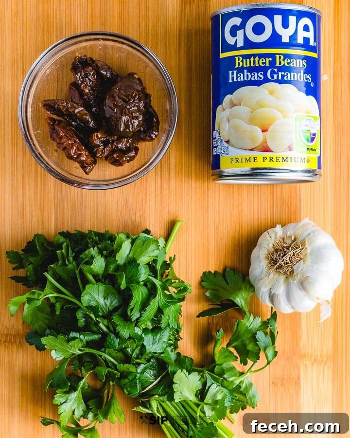 Paccheri Pasta With Butter Beans And Italian Sausage Recipe ingredients shown: butter beans, sundried tomatoes, parsley and garlic.
