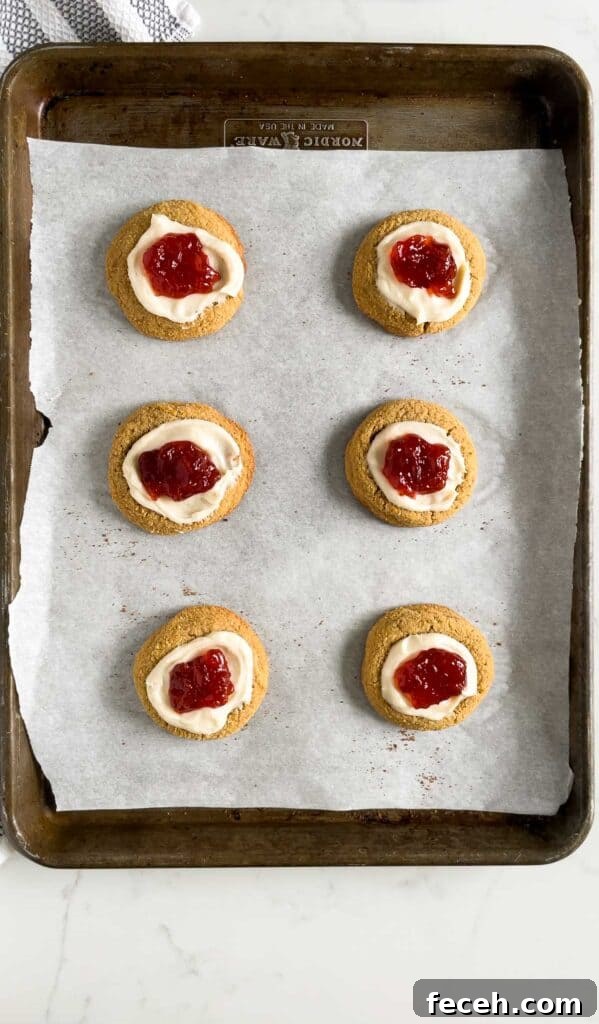strawberry cheesecake cookies on a cookie sheet with parchment paper