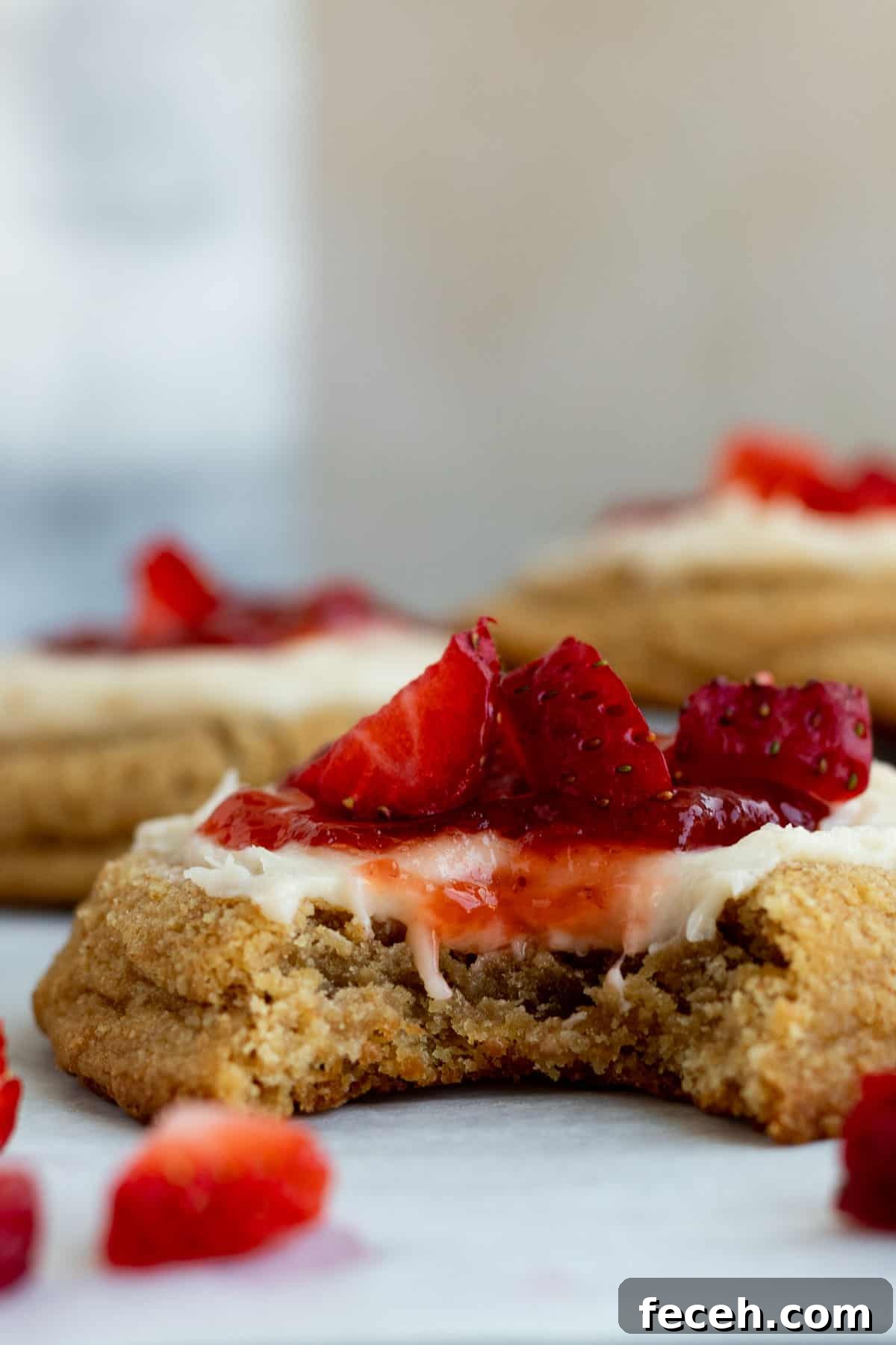 close up of a strawberry cheesecake cookie with a bite out of it