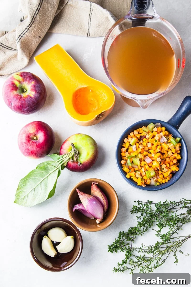 Creamy Butternut Squash and Apple Soup Recipe for Fall 4 Vegetable broth in a glass measuring cup, half a butternut squash, apples, dishtowel, chopped carrots and celery, shallots, garlic, and fresh thyme.