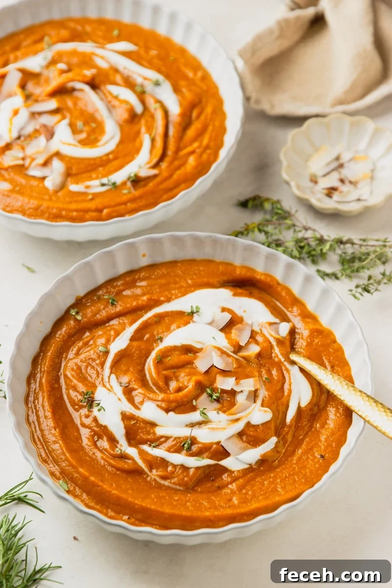 Creamy Butternut Squash and Apple Soup Recipe for Fall 8 Butternut squash apple soup drizzled with yogurt and topped with coconut chips in white bowls, a white bowl of coconut chips, and fresh thyme.
