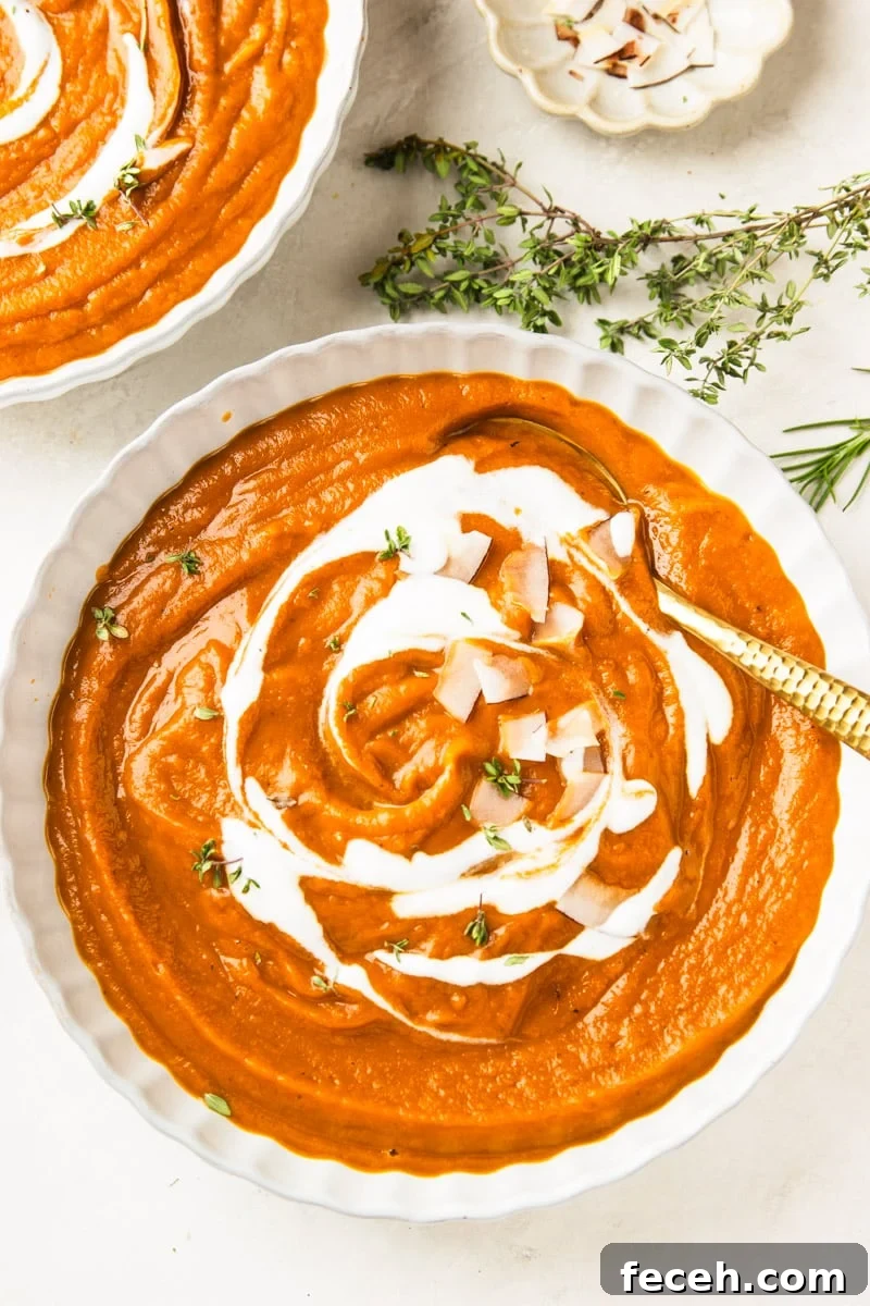 Creamy Butternut Squash and Apple Soup Recipe for Fall 9 Butternut squash apple soup drizzled with yogurt and topped with coconut chips in white bowls, a white bowl of coconut chips, and fresh thyme.