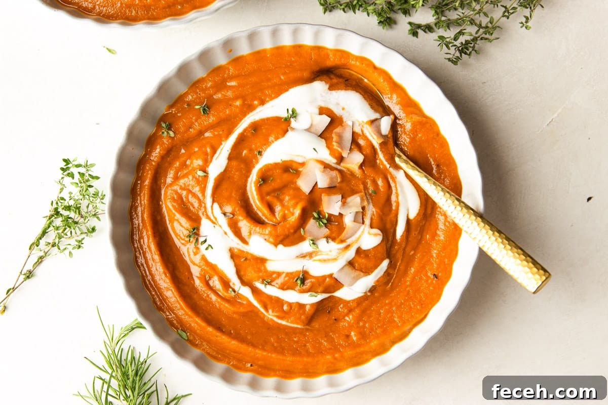 Creamy Butternut Squash and Apple Soup Recipe for Fall 10 Butternut squash apple soup drizzled with yogurt and topped with coconut chips in white bowls and fresh thyme.