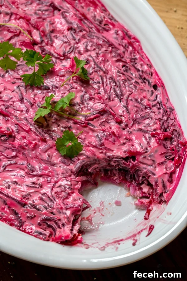Shuba Salad with herring fish, cooked potatoes, carrots, beets and mayo on an oval serving dish