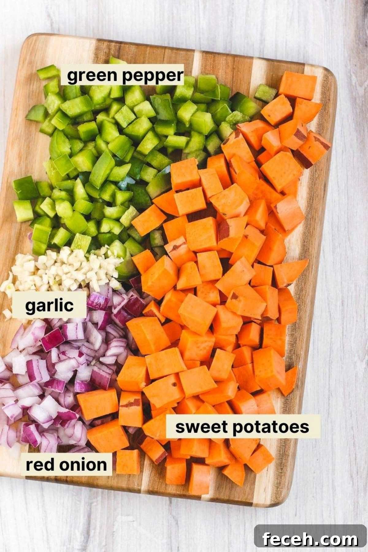 Chopped veggies and garlic on a cutting board with labels next to each food item.