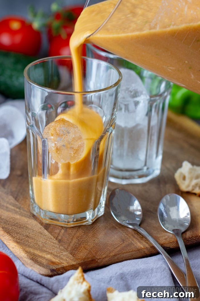 Pouring cold Tomato Gazpacho Soup to the glass