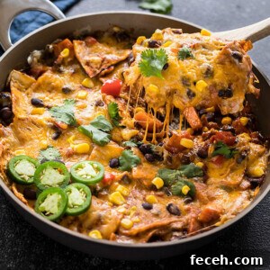 one-pot vegetarian enchiladas in a skillet with a spatula lifting of the cheese