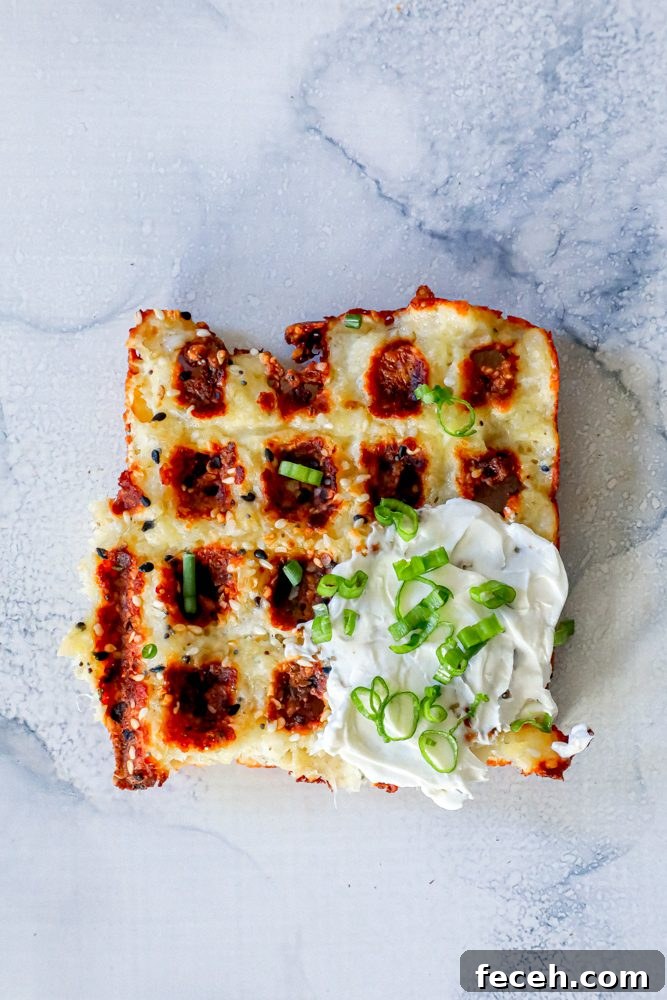 Ultimate Keto Chaffle Recipes: Savory & Sweet Ways to Use Chaffles 2 keto chaffle waffles on a countertop with sour cream and green onions