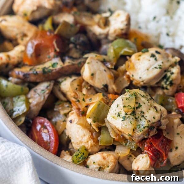 Ultimate Keto Chaffle Recipes: Savory & Sweet Ways to Use Chaffles 5 A close-up of a bowl filled with cooked chicken pieces, bell peppers, tomatoes, and herbs—this Keto Italian Chicken Skillet Dinner is served with a portion of white rice visible in the background.