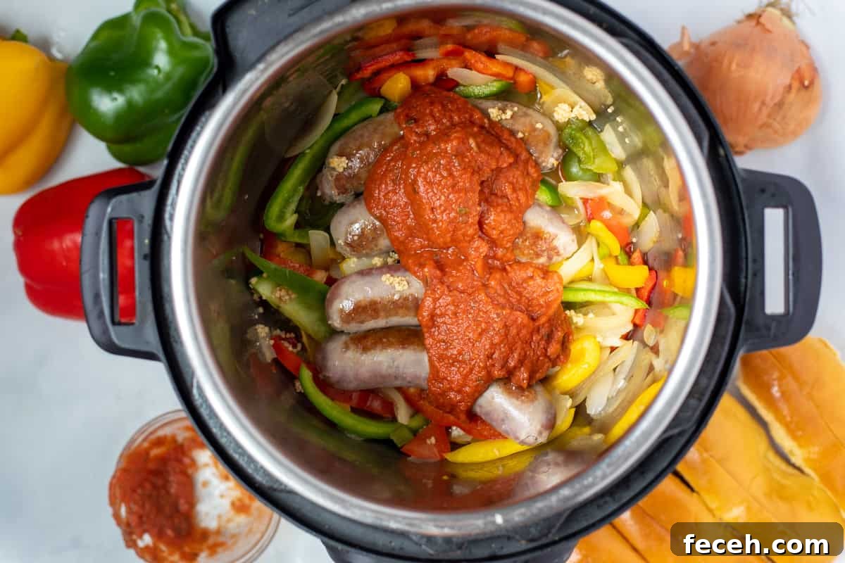 Sausage, peppers, onions, and tomato sauce layered in instant pot. 