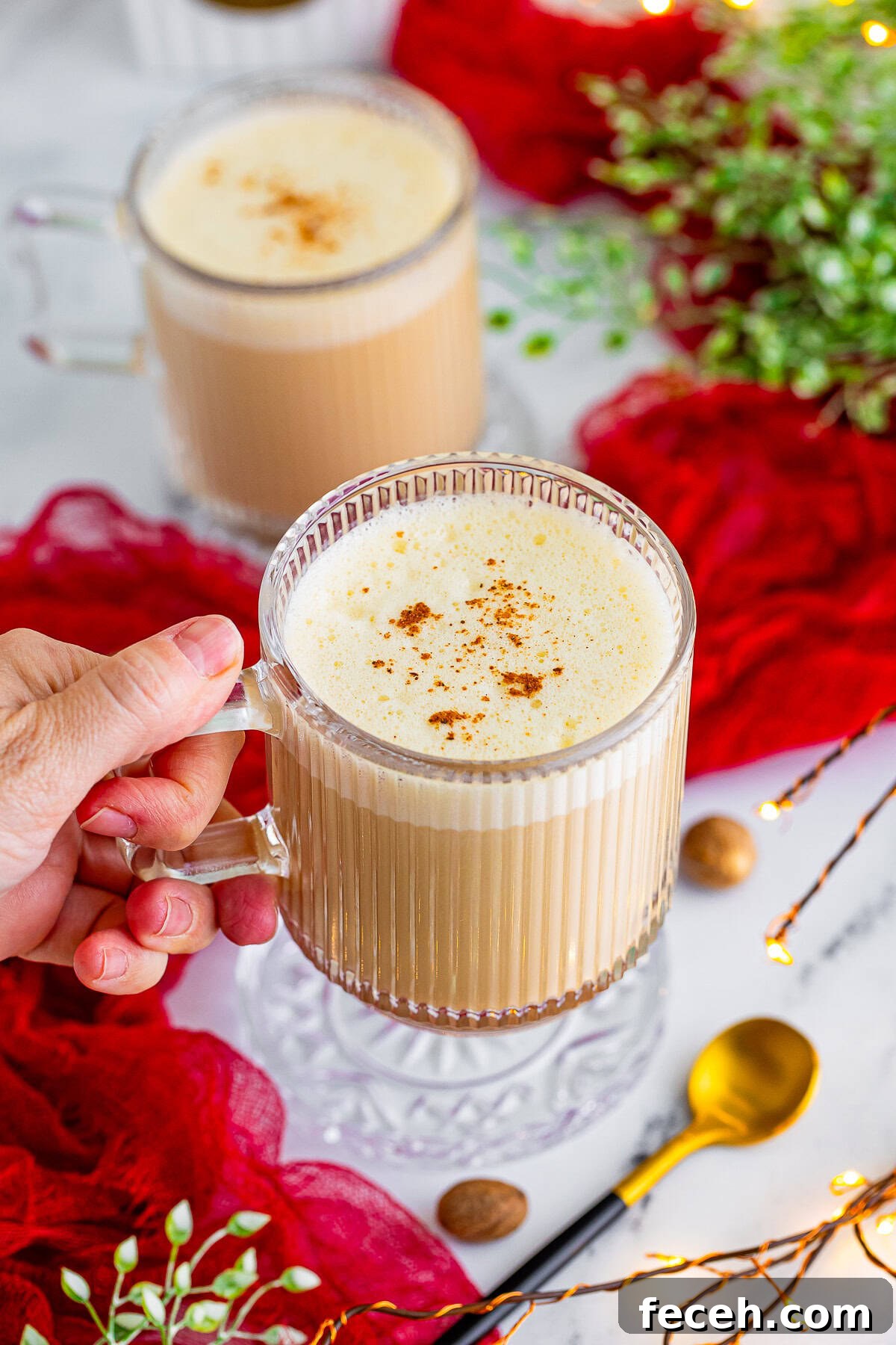 Homemade Eggnog Latte Recipe for Cozy Holiday Masteship 9 a hand holding an eggnog latte in air