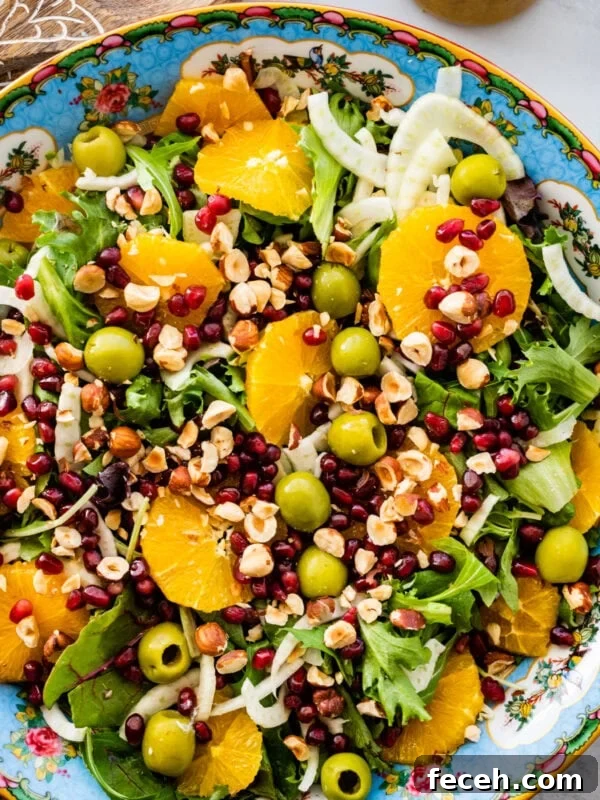 Italian orange and fennel salad with orange dressing on the side. Wooden salad servers on the side.