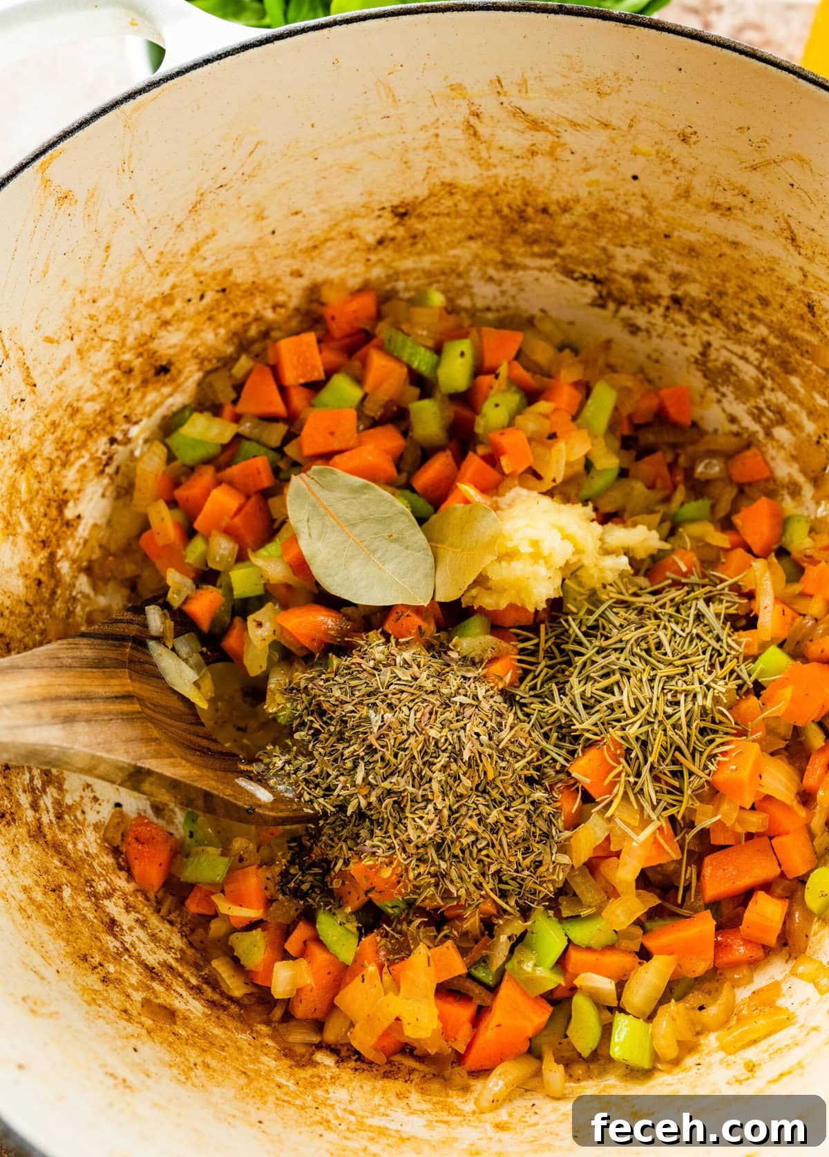 adding the spices to the pot with cooked vegetables.