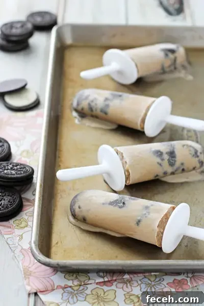 Four melty Coffee Popsicles on a baking sheet.