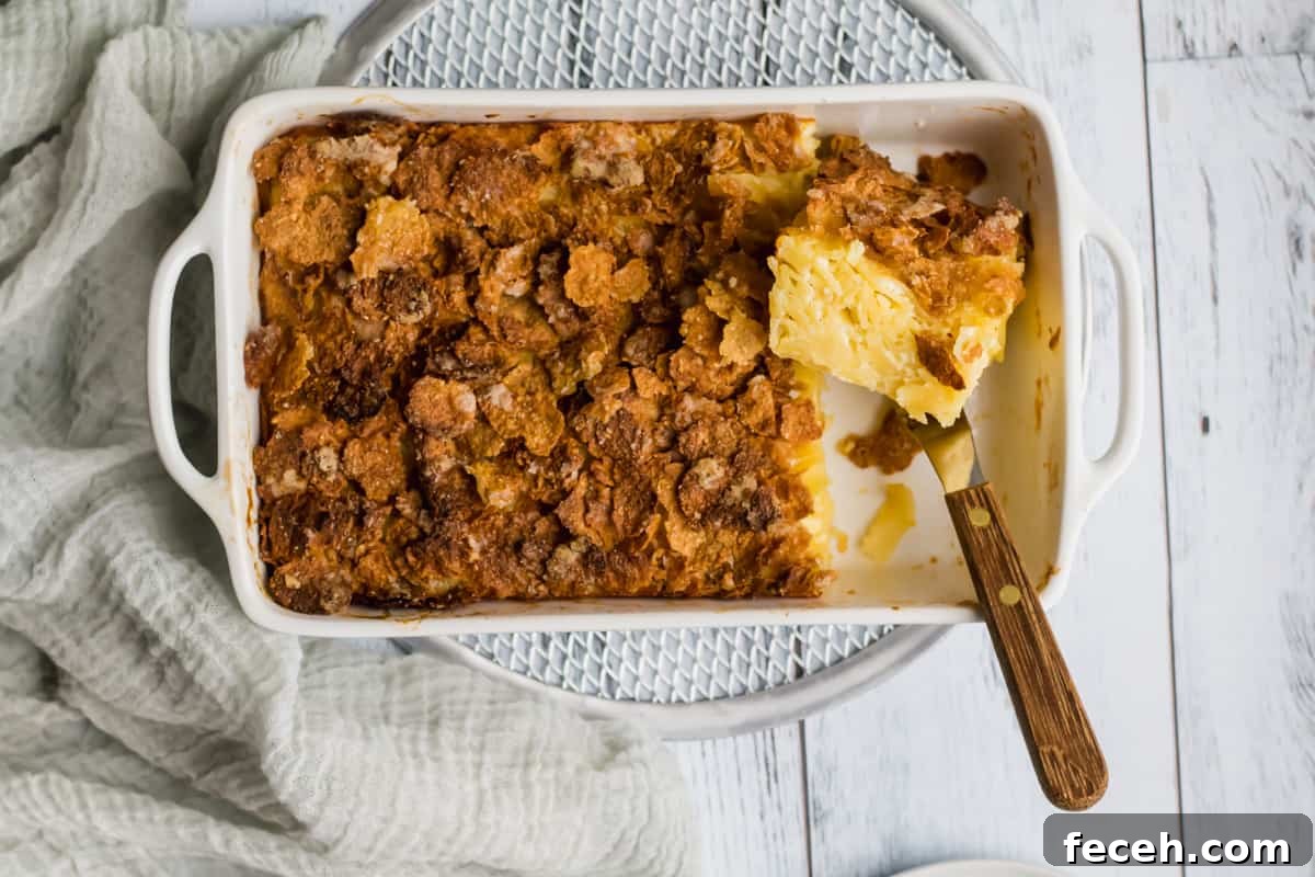 noodle kugel in a white baking dish with a piece cut out