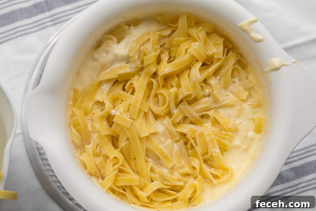 noodles added to custard mixture in a mixing bowl.