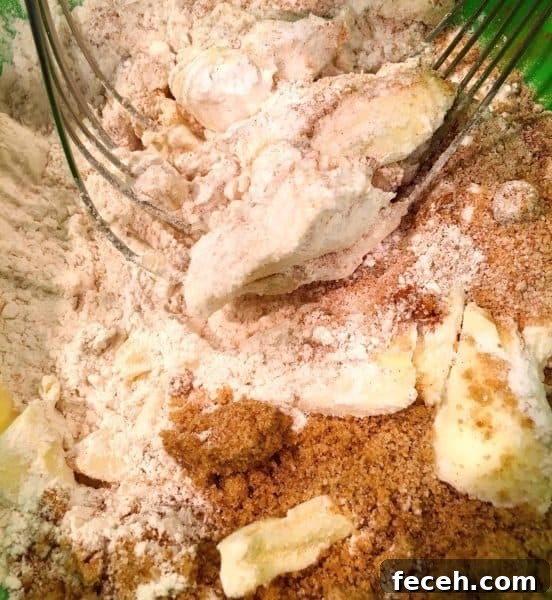 bowl full of crumb toppings with pastry blender to create crumb topping