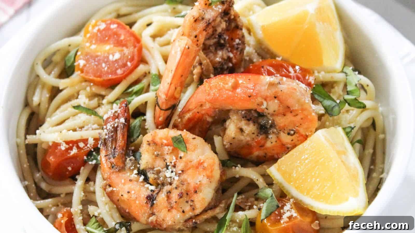 A bowl of pasta with shrimp and tomatoes.