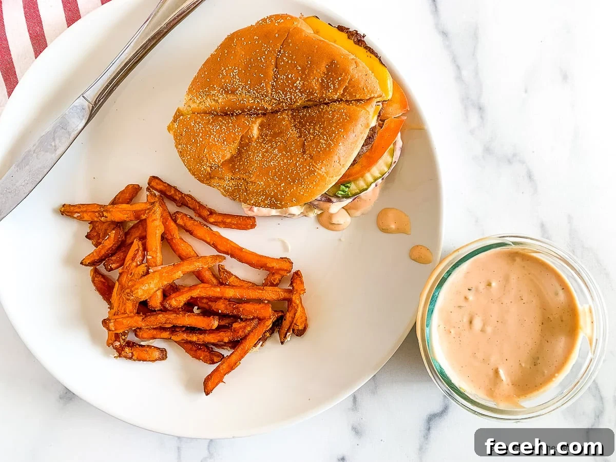 In-N-Out Spread Copycat Recipe: How to Make the Famous Sauce 3 Plated burger and fries next to a small bowl of In n Out sauce.