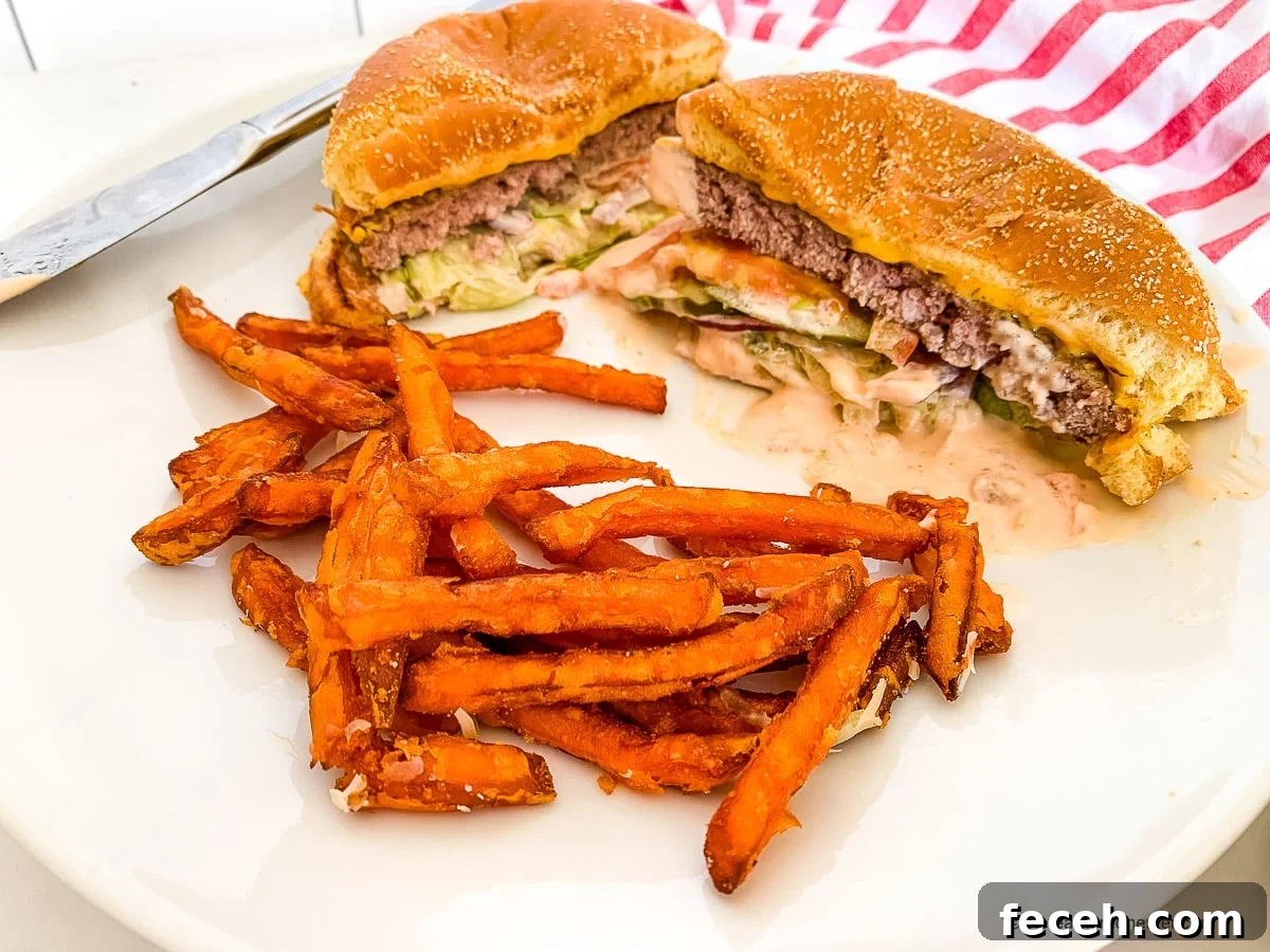 In-N-Out Spread Copycat Recipe: How to Make the Famous Sauce 8 Sandwich on a bun cut in half with French fries on a white plate.