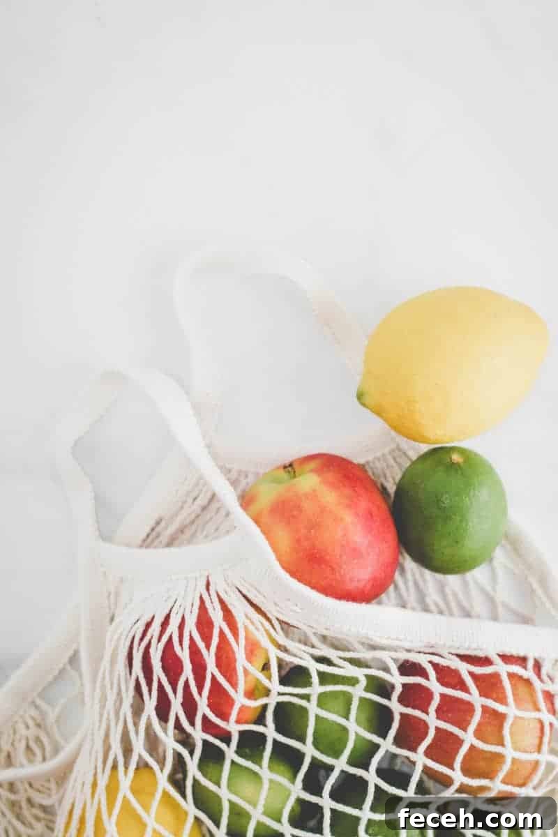 Ikea KUNGSFORS mesh produce bag with apples, lemons, and limes spilling out.