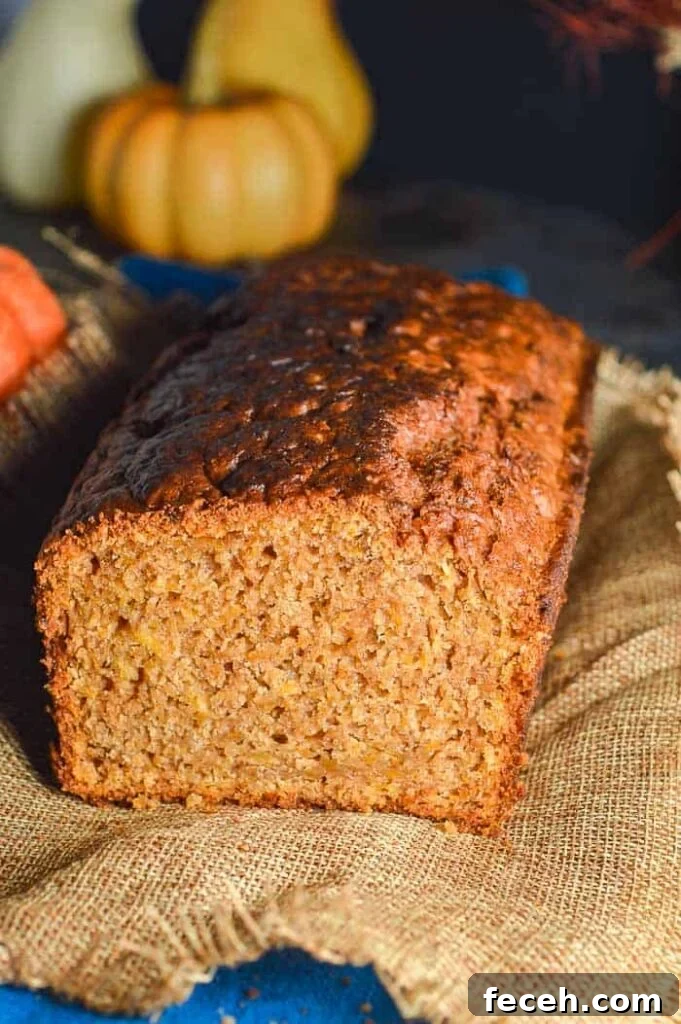 Moist Vegan Pumpkin Bread Recipe for Fall Baking 2 A front cross section view of a golden brown quickbread with pumpkins in the background
