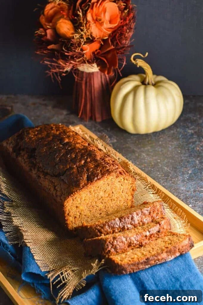Moist Vegan Pumpkin Bread Recipe for Fall Baking 4 A quickbread with a white pumpkin and red flowers in the bakcground