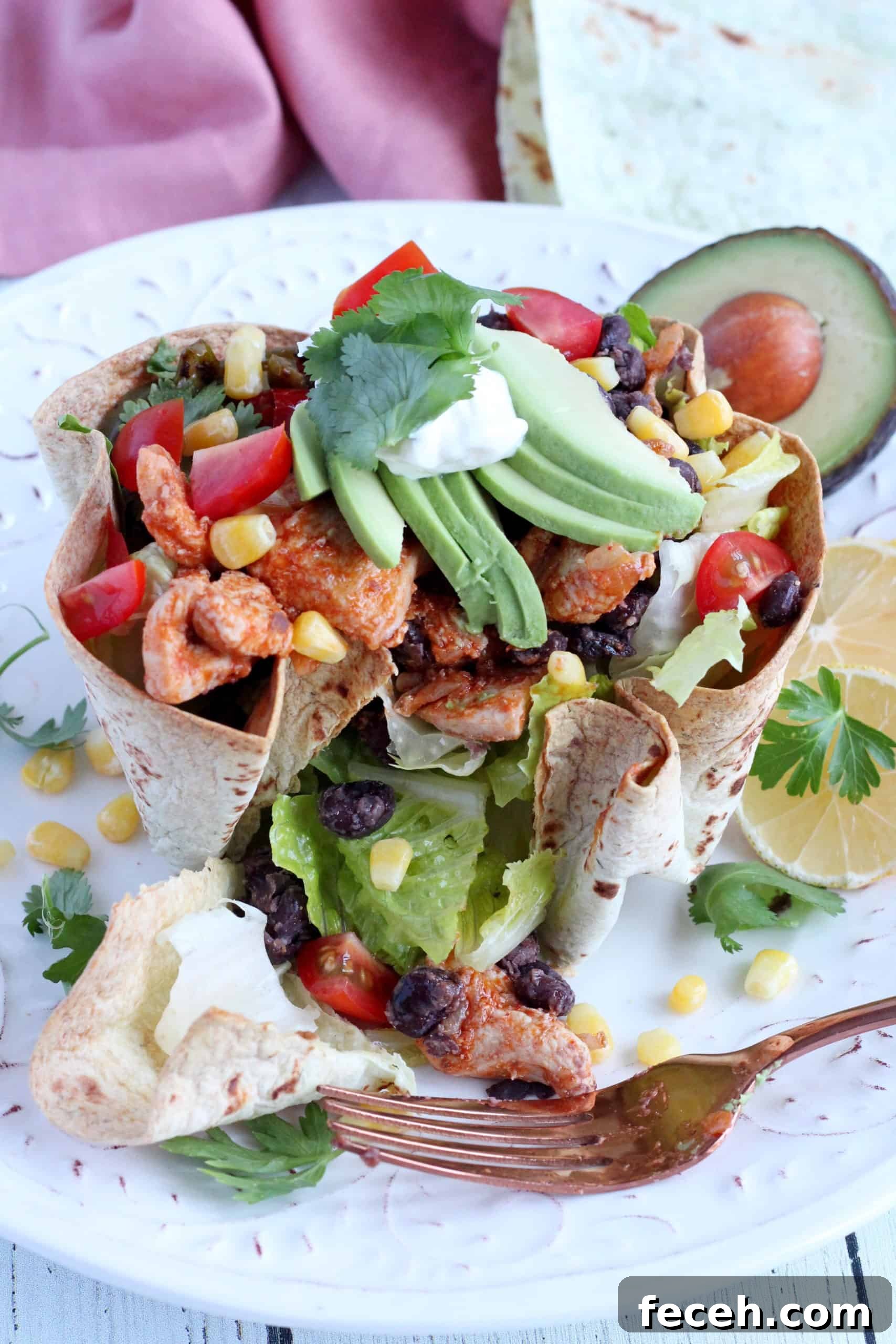 Bowl made from tortilla filled with salad and chicken.