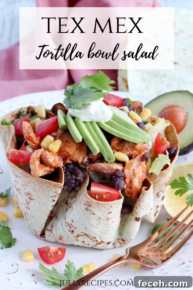 Tortilla bowl on white plate filled with delicious chicken meat, topped with vegetables like tomatoes, corn, onion, salad, avocado, sour cream and fresh parsley.