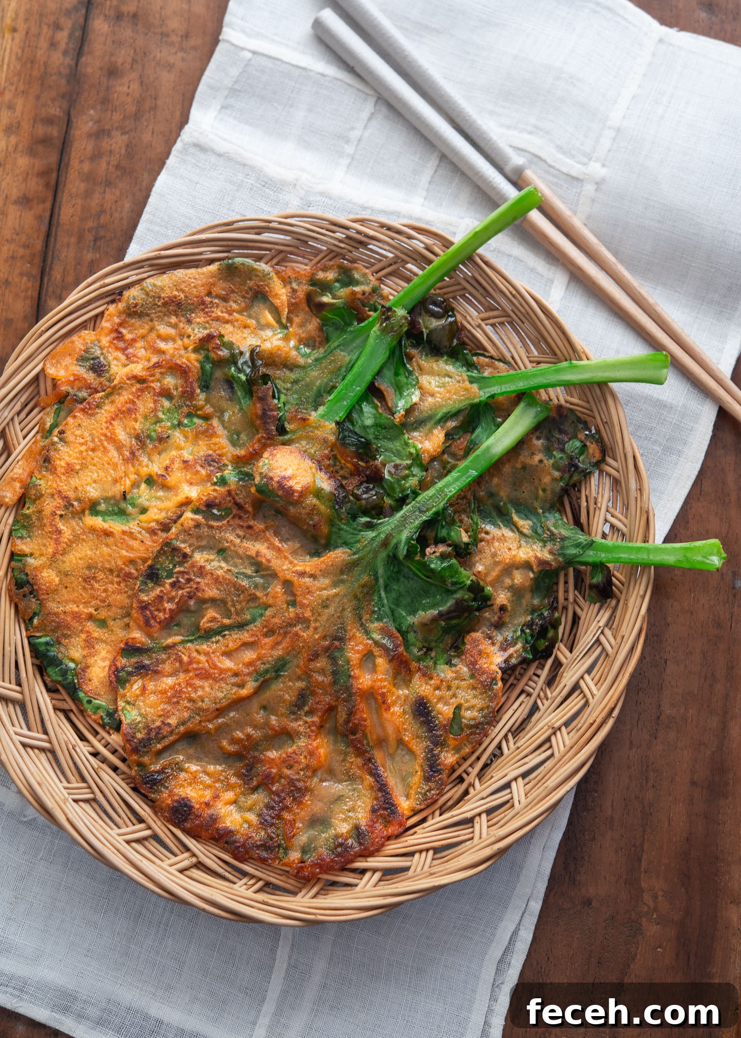 Kale gochujang pancake (jangtteok) served in a woven tray for a rustic presentation