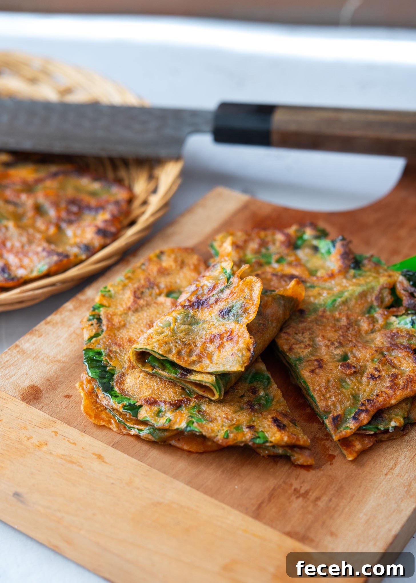Sliced kale gochujang pancakes (jangtteok) on a cutting board