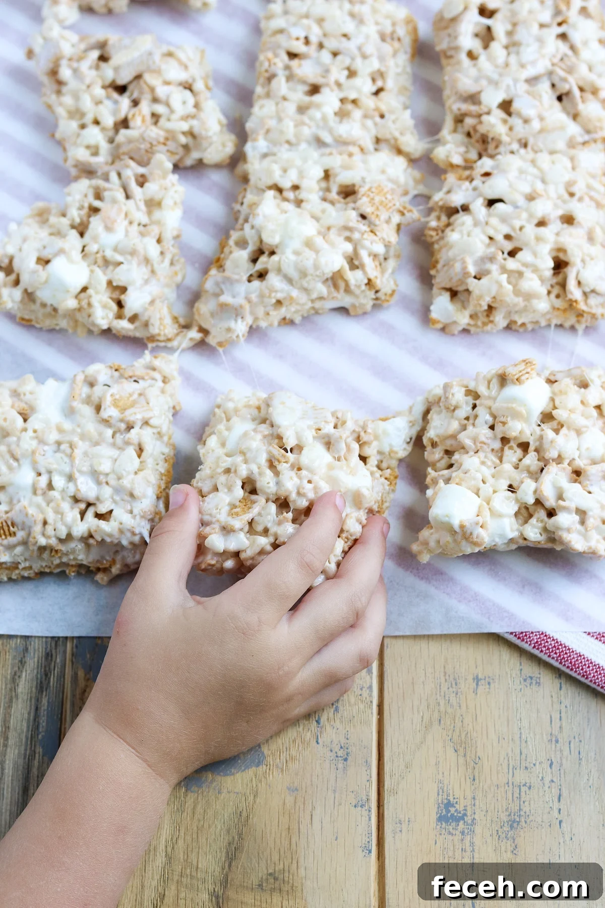 Golden Graham Rice Krispie Treats Recipe — Crispy Marshmallow Squares 2 Childs hand reaching for a marshmallow treat