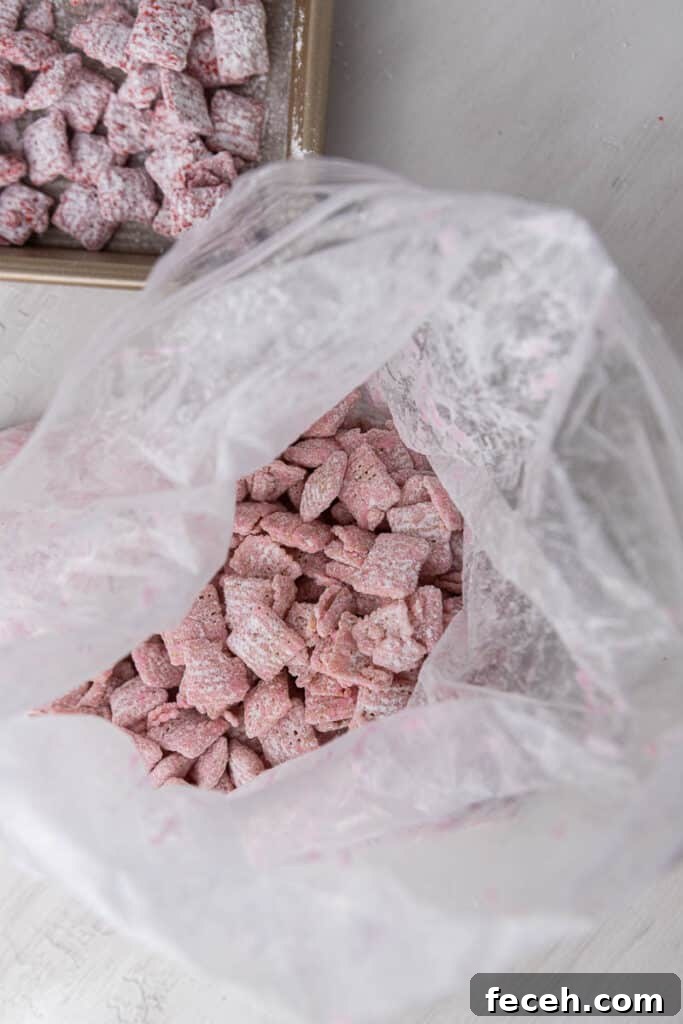 Valentine’s muddy buddies being shaken in powdered sugar in a ziplock bag