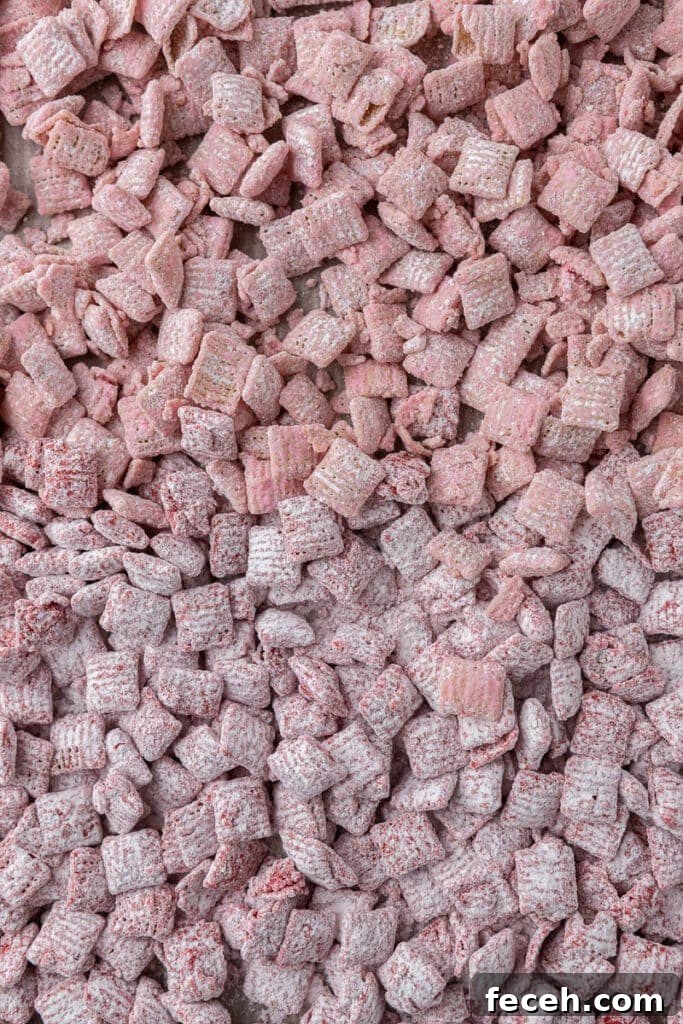 Valentine’s muddy buddies with pink and red M&M’s and heart sprinkles