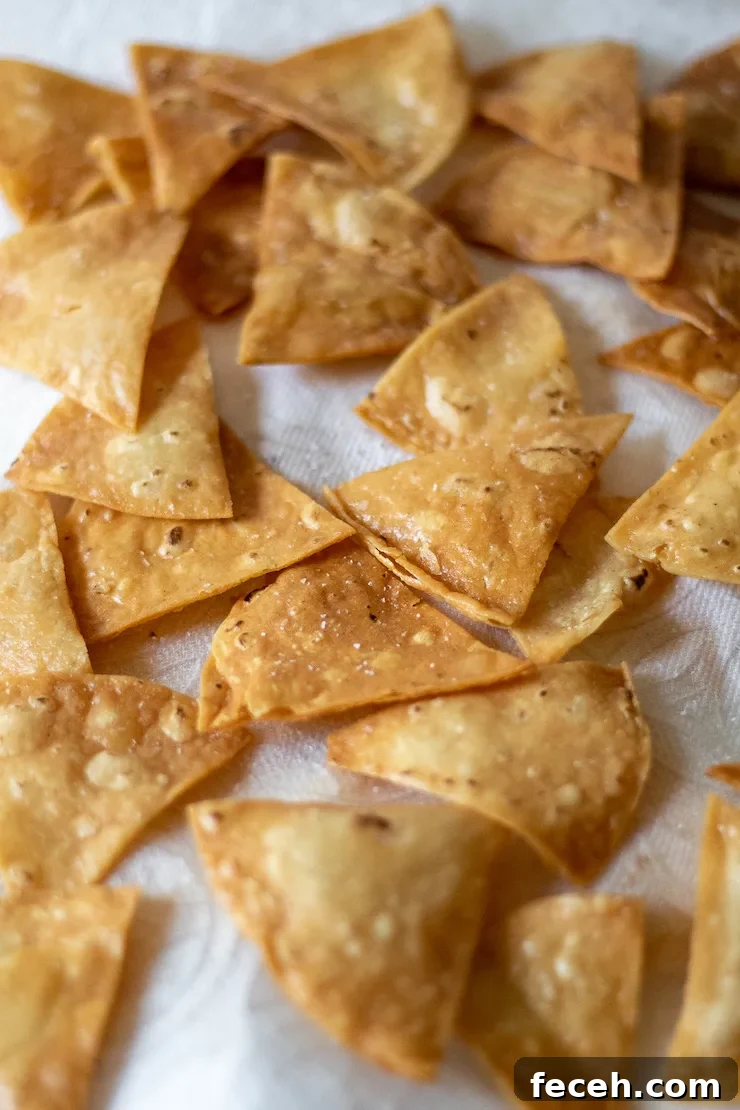 Tortilla chips draining on paper towels.