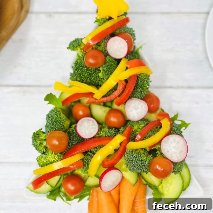 crudite Christmas tree platter - raw veg made into the shape of a christmas tree - includes broccoli, cucumber, carrots, celery, bell peppers, radish and tomatoes