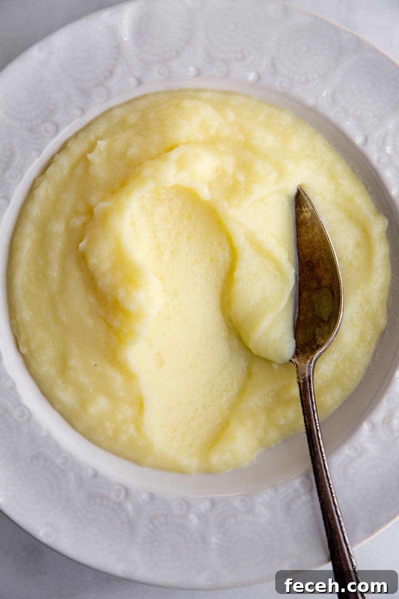 Pomme puree in a bowl with a serving spoon. 