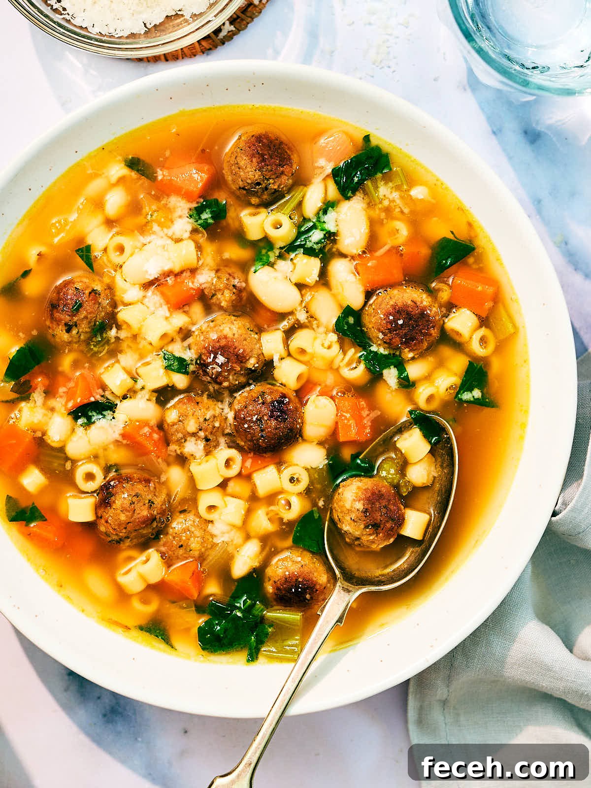 Vegan Italian Wedding Soup Recipe with Plant-Based Meatballs 2 Vegan Italian Wedding Soup in a bowl with a spoon.