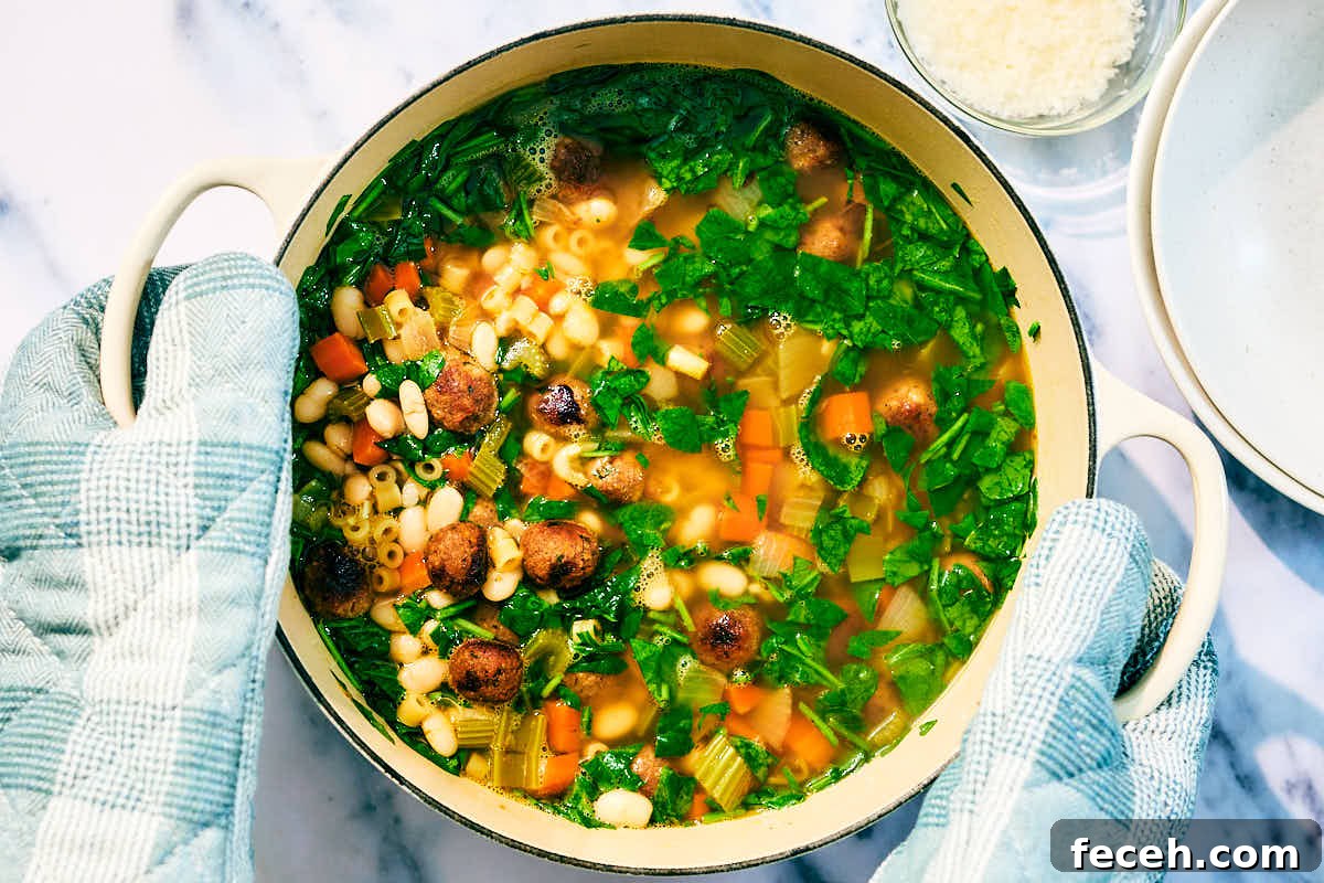 Vegan Italian Wedding Soup Recipe with Plant-Based Meatballs 12 Vegan Italian Wedding Soup with beans and spinach in a pot.
