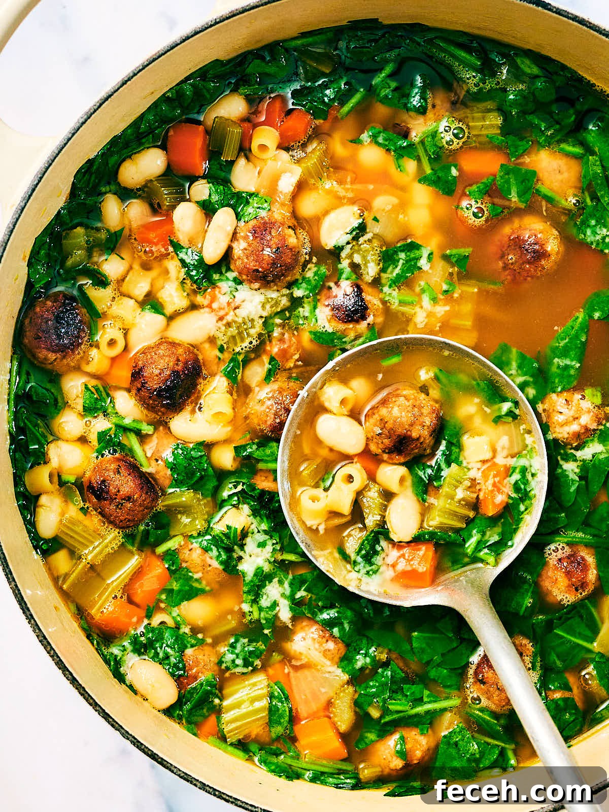 Vegan Italian Wedding Soup Recipe with Plant-Based Meatballs 14 Vegan Italian Wedding Soup with beans in a pot with a ladle.